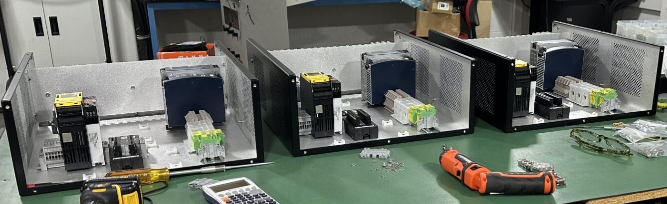 Three electro mechanical enclosures open for assembly on the HPN Electronics production bench