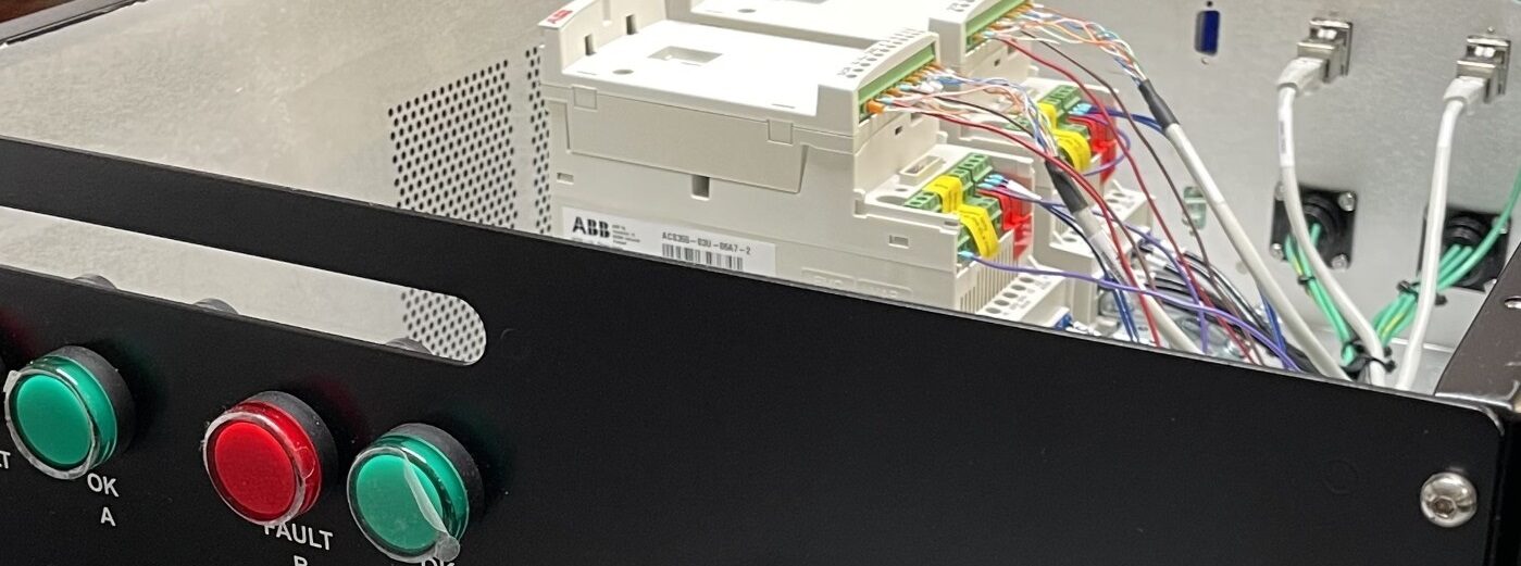 Close up of a finished control panel with status indicator buttons and a compliance labeled I/O module, built by HPN Electronics